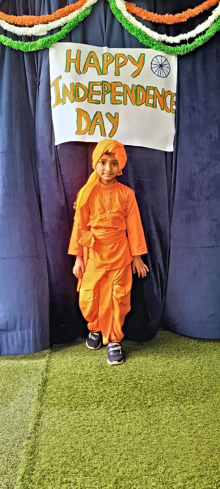 A child dressed as Swami Vivekananda in saffron robes and turban