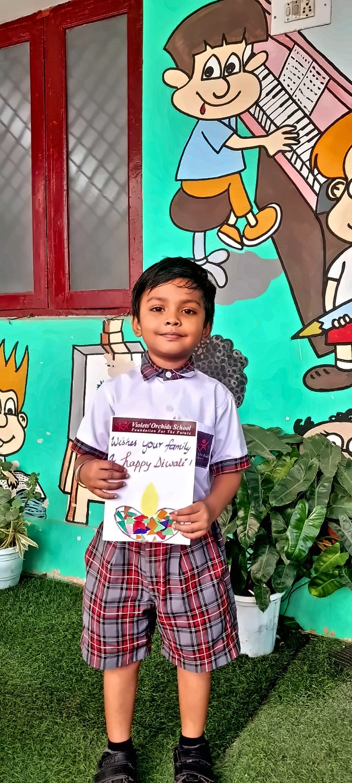 A boy holding his handmade Happy Diwali card