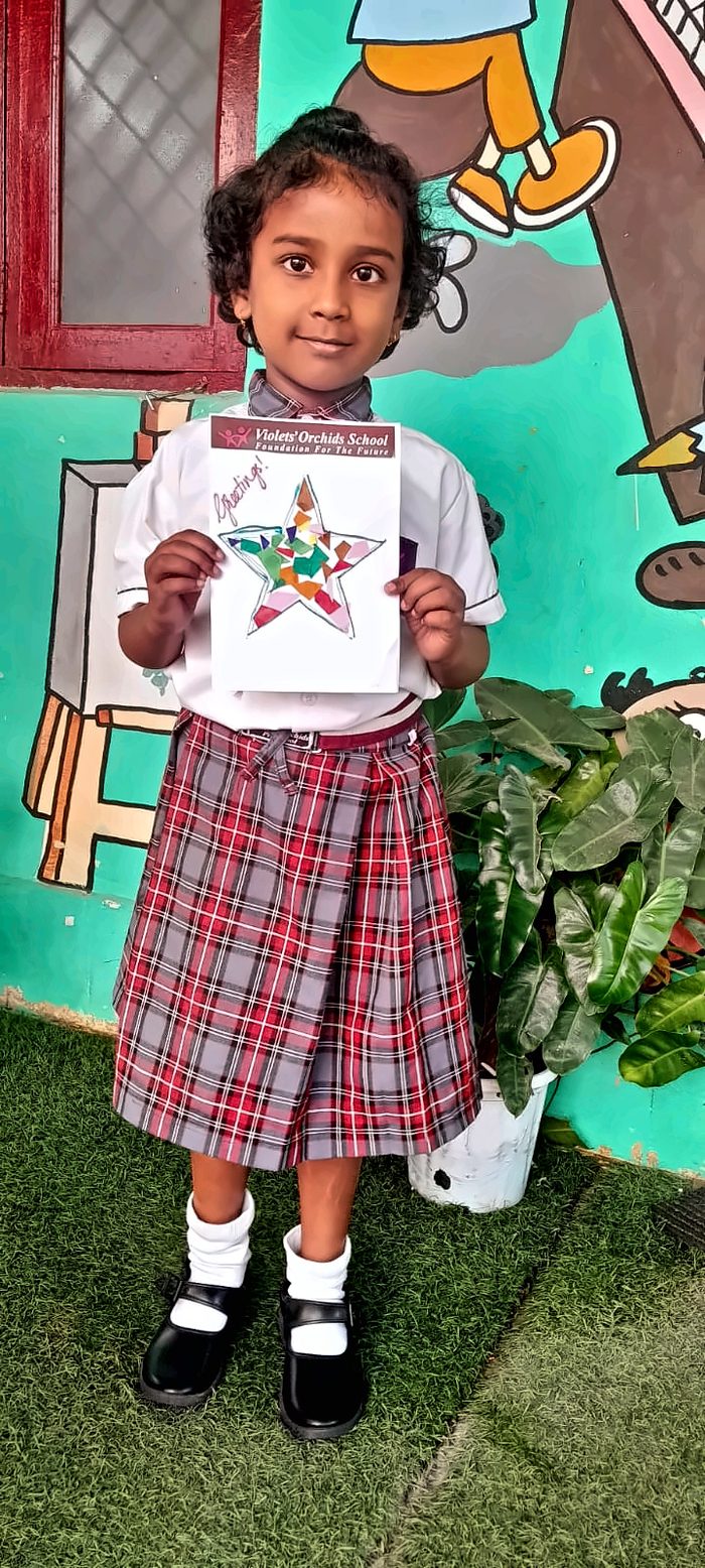 A girl holding a greetings card with a colourful mosaic star