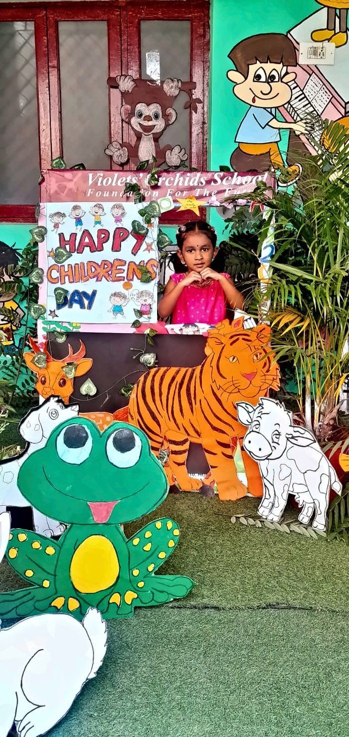 A girl at the Children's Day photo booth surrounded by animal cutouts