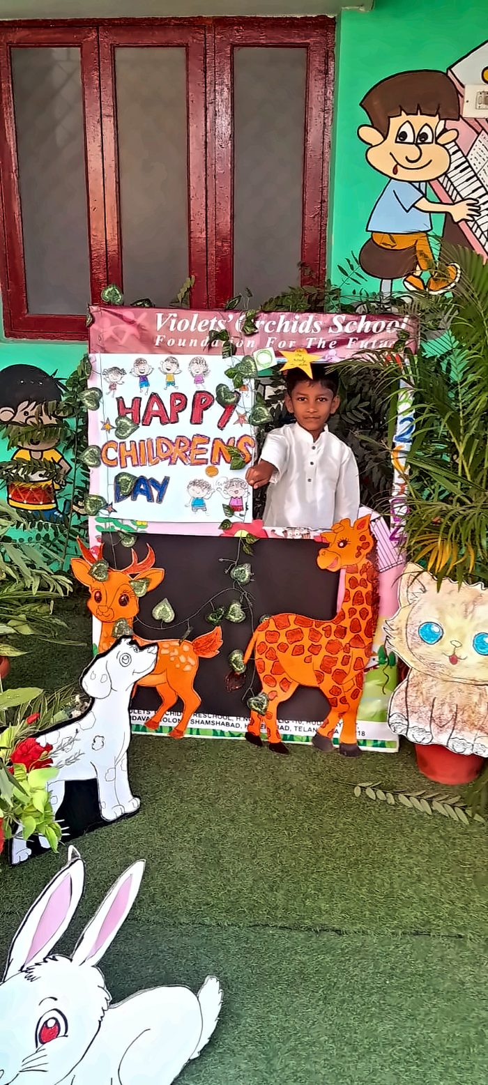A boy posing at the Children's Day booth beside a giraffe cutout
